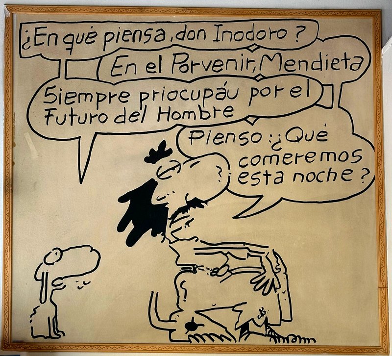 Cartel de Mendieta con la viñeta de Inodoro Pereyra y Mendieta: '¿En qué piensa, don Inodoro? — En el porvenir, Mendieta. Siempre priocupáu por el futuro del hombre. — Pienso: ¿qué comeremos esta noche?'